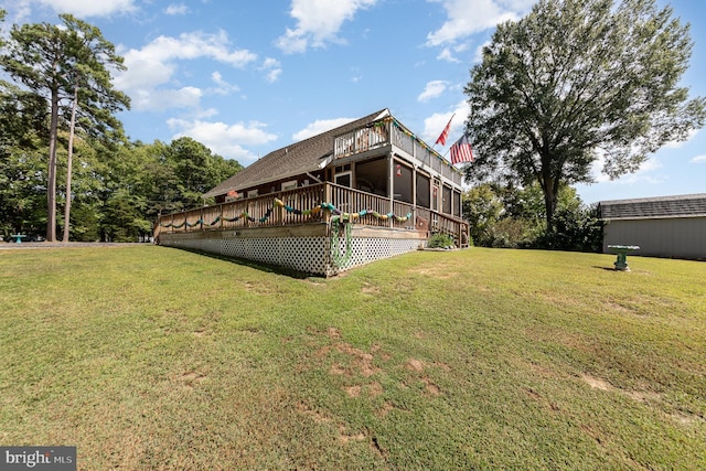 rear view of house with a deck and a lawn