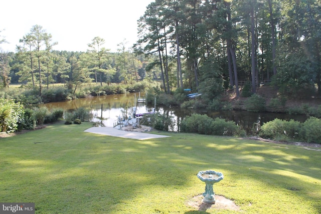 view of yard with a forest view and a water view