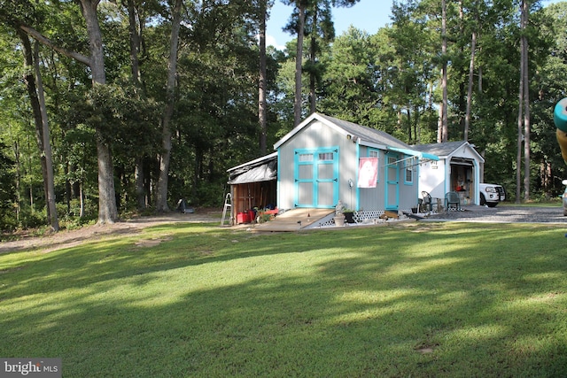 view of front of house featuring a storage unit, an outbuilding, and a front yard