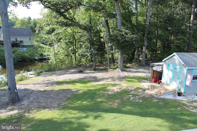 view of yard featuring a water view and a storage unit