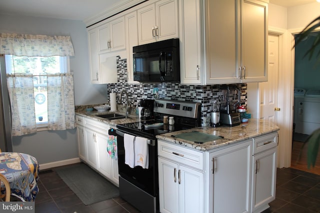 kitchen with decorative backsplash, dark tile patterned flooring, stainless steel range with electric stovetop, sink, and washer and dryer