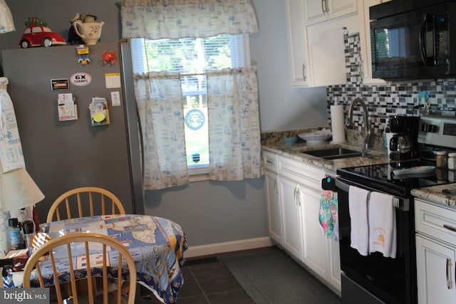 kitchen with dark tile patterned floors, tasteful backsplash, range with electric cooktop, and white cabinets