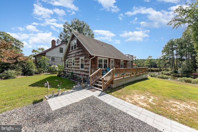 view of front of property with a wooden deck, a patio, a chimney, and a front lawn