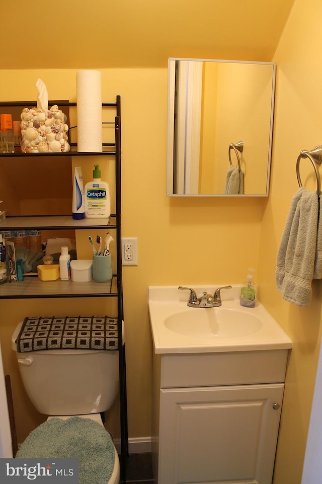 half bathroom with vanity and toilet