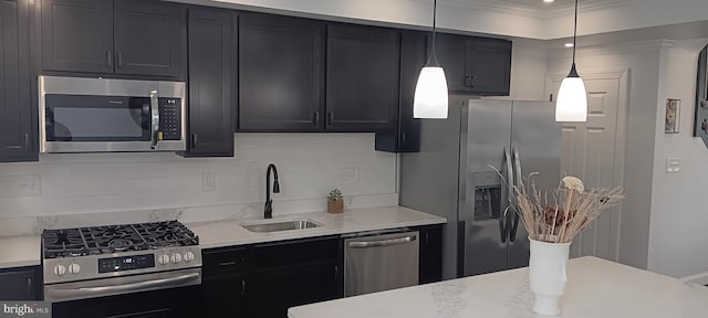 kitchen featuring pendant lighting, ornamental molding, sink, decorative backsplash, and appliances with stainless steel finishes