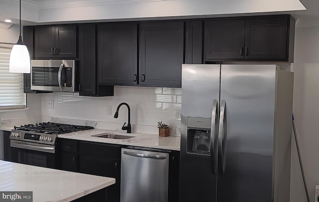 kitchen with decorative light fixtures, stainless steel appliances, crown molding, and sink