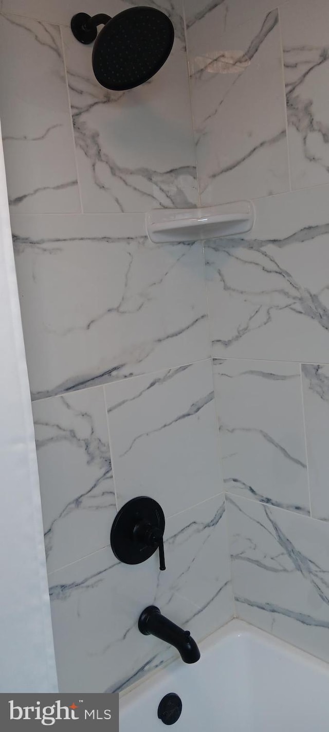 interior details with tiled shower / bath combo