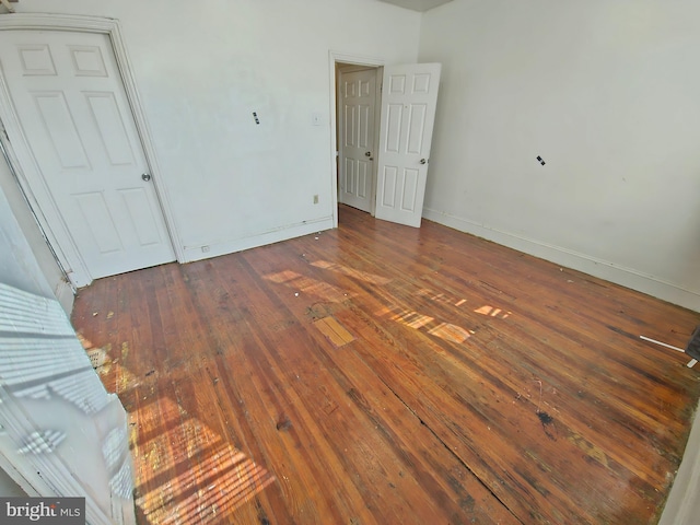 unfurnished bedroom with hardwood / wood-style floors and baseboards