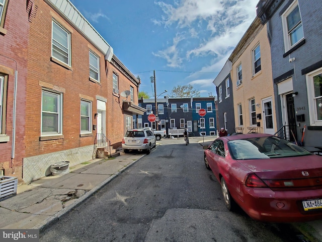 view of street with curbs, traffic signs, street lighting, and sidewalks