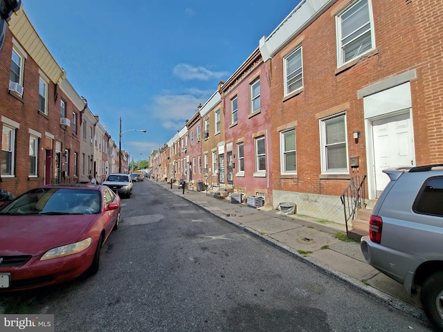 view of street featuring sidewalks, a residential view, curbs, and street lights