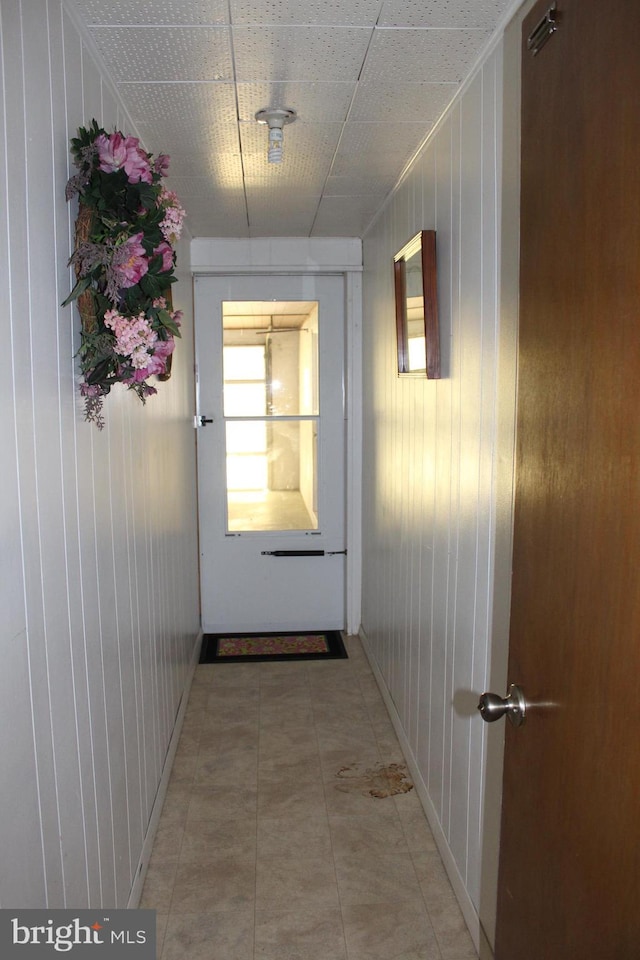 corridor featuring wooden walls