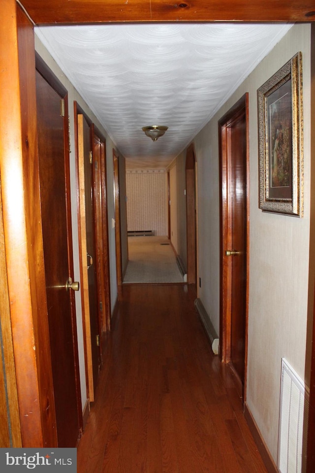 corridor with visible vents and wood finished floors