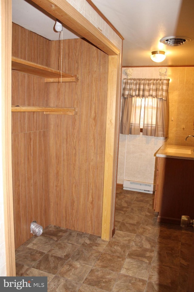 clothes washing area featuring a sink and a baseboard radiator