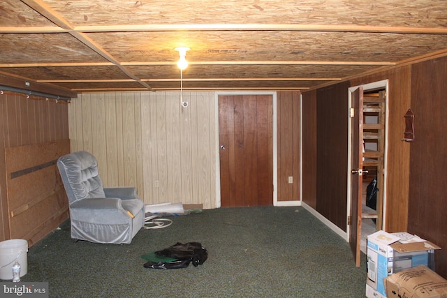 basement featuring carpet floors and wooden walls