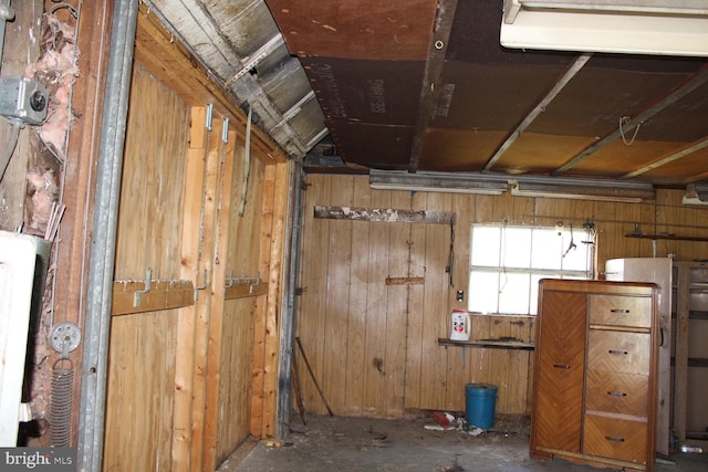 misc room with wooden walls and concrete floors