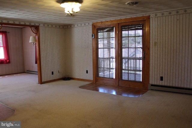 entryway featuring a baseboard heating unit, carpet floors, baseboards, and a baseboard radiator