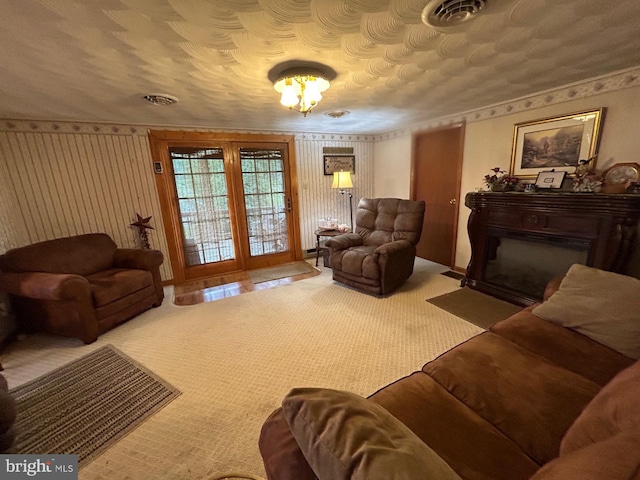 living room featuring carpet flooring, a fireplace with flush hearth, and visible vents