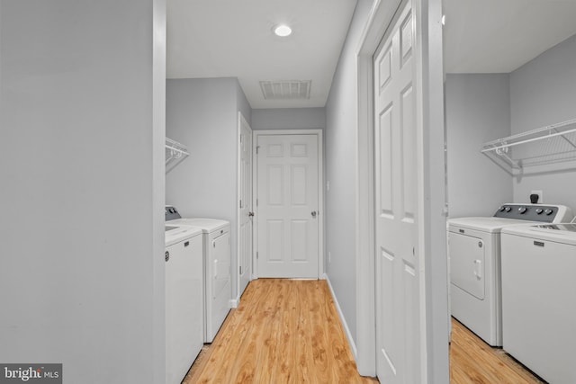 washroom with light wood-type flooring and separate washer and dryer