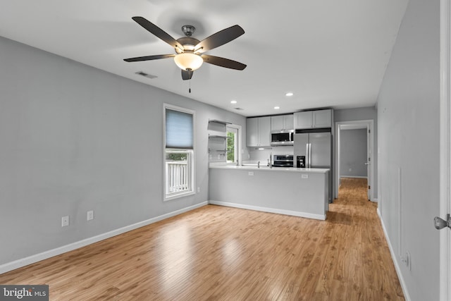 unfurnished living room featuring ceiling fan and light hardwood / wood-style flooring