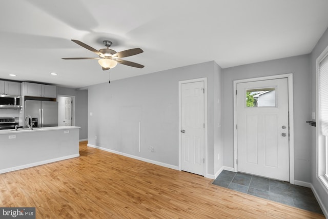 entryway featuring ceiling fan, sink, and light hardwood / wood-style floors