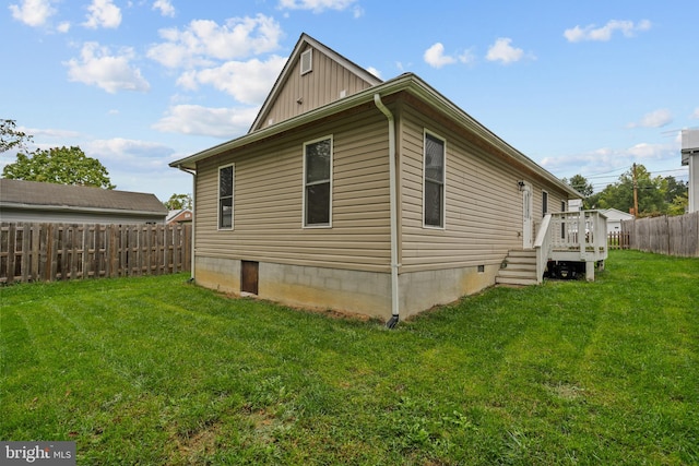 view of side of home with a lawn and a wooden deck