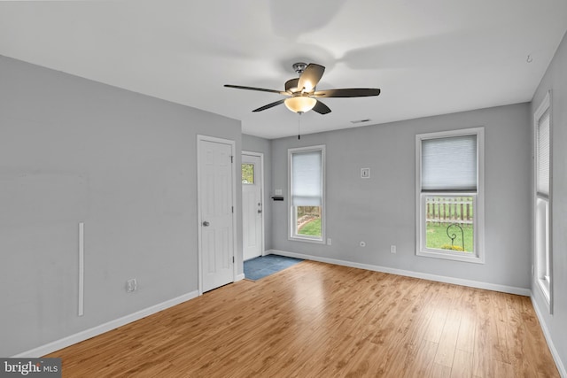 empty room with light wood-type flooring and ceiling fan