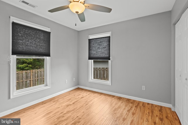 unfurnished bedroom with ceiling fan, light hardwood / wood-style flooring, and a closet