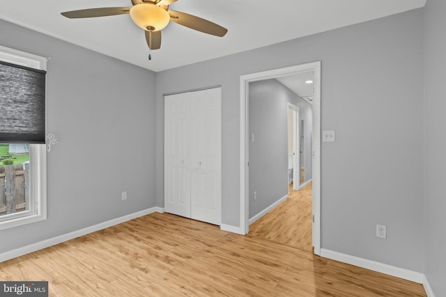 unfurnished bedroom featuring light hardwood / wood-style floors, ceiling fan, and a closet