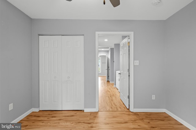 unfurnished bedroom with ceiling fan, a closet, and light hardwood / wood-style floors