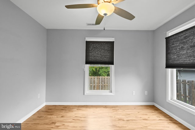 spare room featuring light hardwood / wood-style flooring, ceiling fan, and plenty of natural light