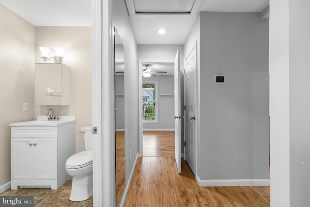 bathroom featuring ceiling fan, hardwood / wood-style flooring, vanity, and toilet