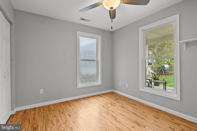 unfurnished room with light hardwood / wood-style floors, ceiling fan, and a healthy amount of sunlight