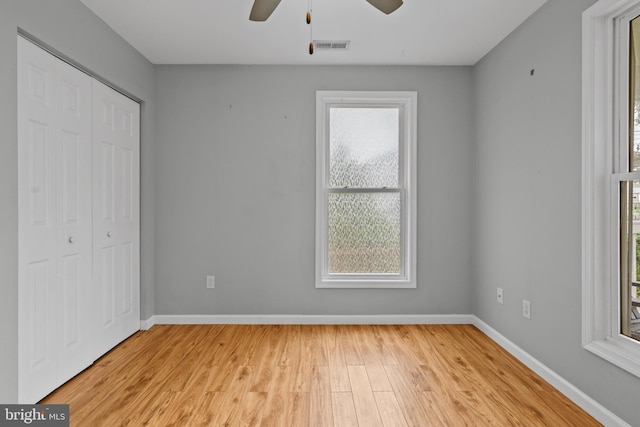 unfurnished bedroom featuring light hardwood / wood-style floors, ceiling fan, and a closet