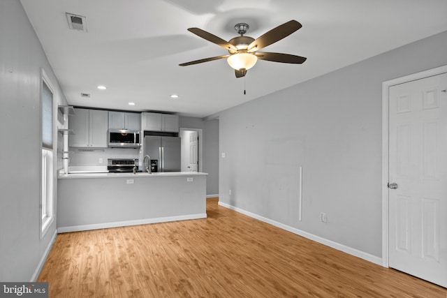 unfurnished living room featuring ceiling fan, light hardwood / wood-style flooring, and sink