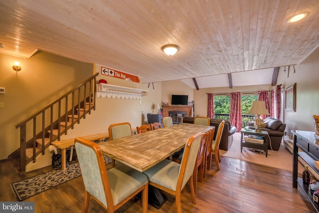 dining space with wood ceiling, a fireplace, lofted ceiling with beams, and dark hardwood / wood-style floors