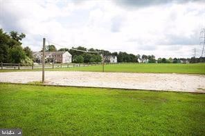 surrounding community with volleyball court and a lawn