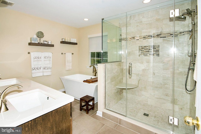 full bath with visible vents, a stall shower, a sink, a freestanding bath, and tile patterned floors