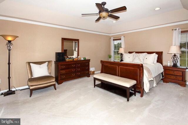 bedroom with light carpet, ceiling fan, and a raised ceiling