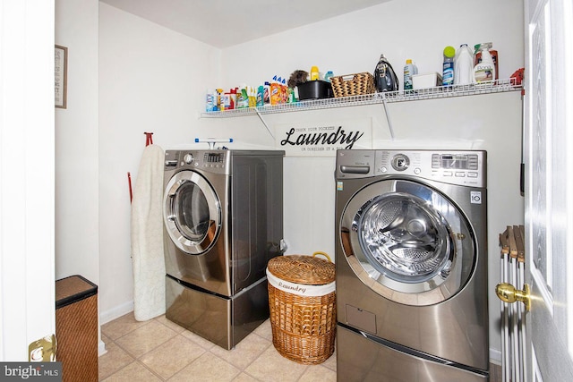 laundry area featuring light tile patterned floors, baseboards, separate washer and dryer, and laundry area