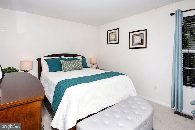 carpeted bedroom with visible vents and baseboards