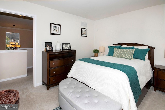 carpeted bedroom with crown molding and an inviting chandelier