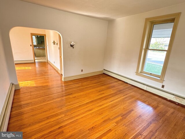 spare room with a baseboard radiator and light wood-type flooring