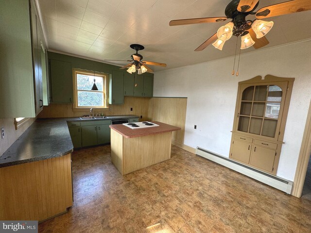 kitchen featuring green cabinetry, a kitchen island, baseboard heating, ceiling fan, and sink