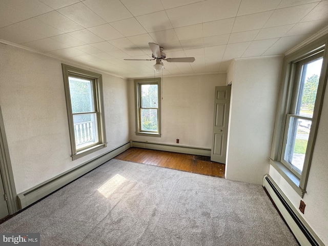 unfurnished room featuring a baseboard radiator and a wealth of natural light