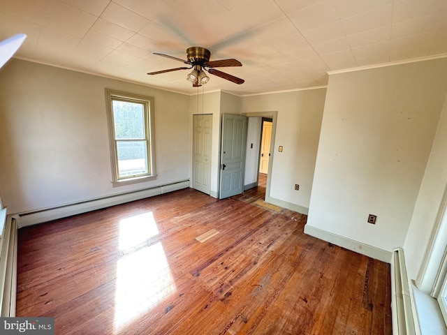 unfurnished bedroom featuring ceiling fan, baseboard heating, ornamental molding, and wood-type flooring