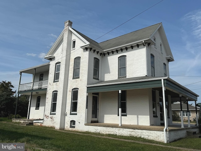 exterior space with a balcony, a front lawn, and covered porch