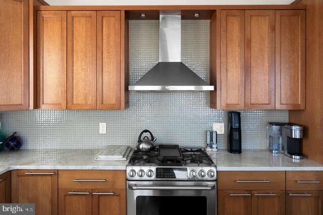 kitchen featuring decorative light fixtures, wall chimney exhaust hood, light hardwood / wood-style flooring, a breakfast bar, and stainless steel appliances