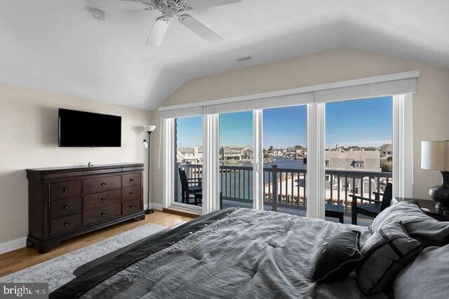 bedroom featuring lofted ceiling, hardwood / wood-style floors, ceiling fan, and access to exterior