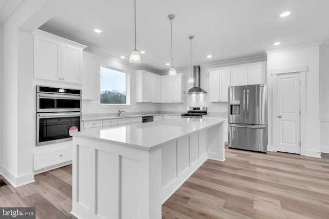 kitchen featuring white cabinetry, a center island, wall chimney exhaust hood, and stainless steel appliances