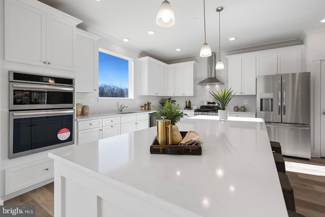 1333 German Driveway, Hanover, MD 21076 - kitchen featuring appliances with stainless steel finishes, wall chimney exhaust hood, a kitchen breakfast bar, light countertops, and white cabinets